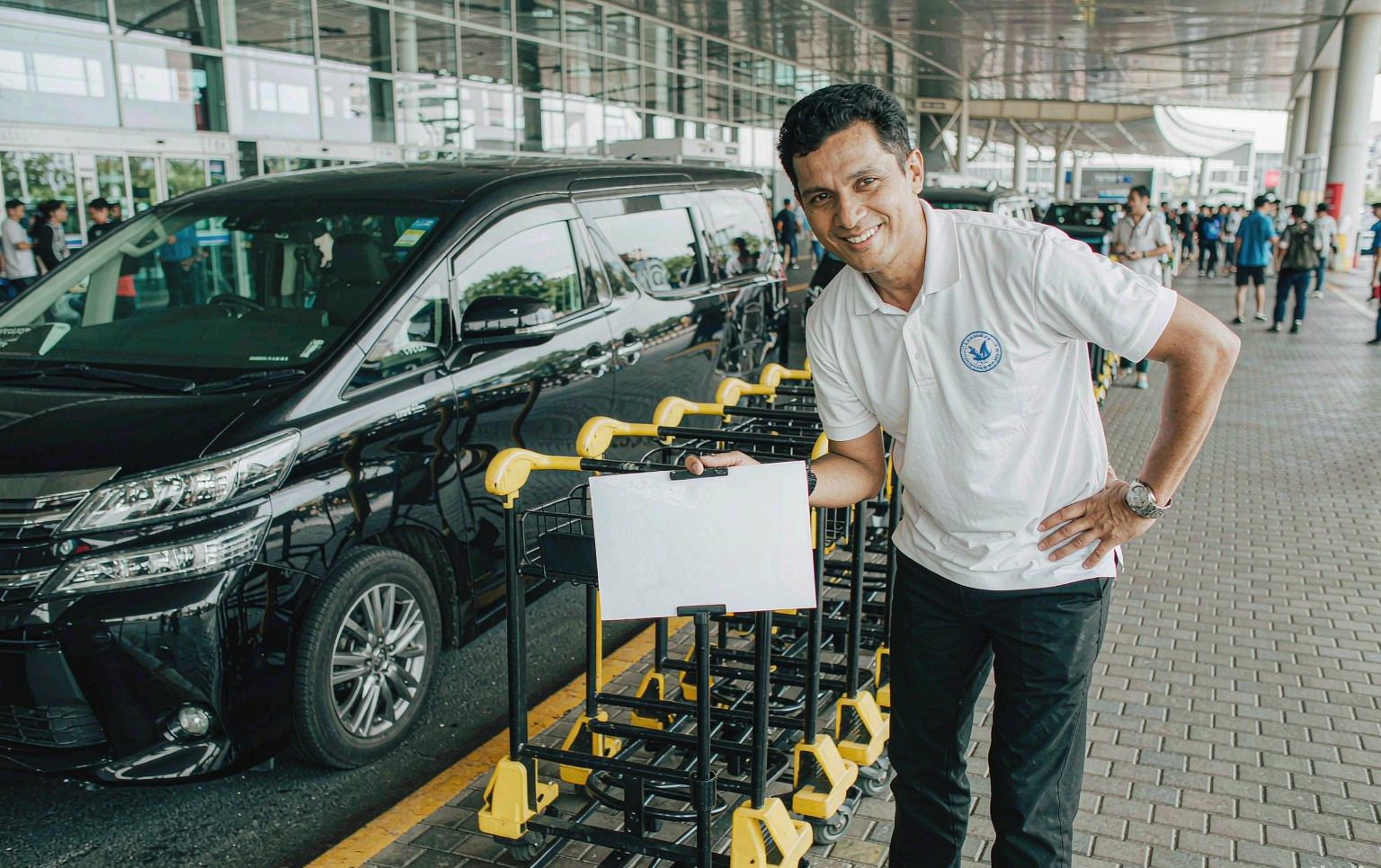 A driver waiting with a name sign at airport arrivals